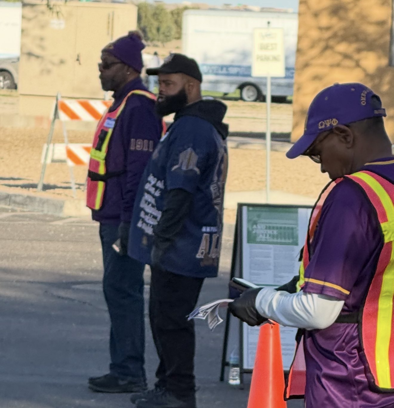Volunteers in safety vests managing arrivals at a community event
